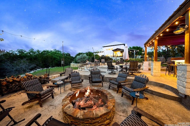view of patio / terrace with an outdoor fire pit and a bar