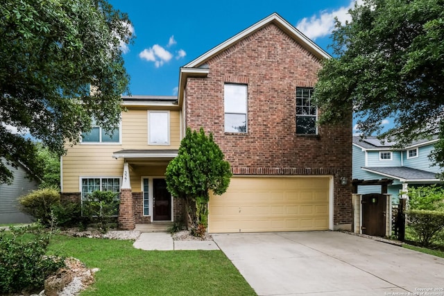 traditional home featuring driveway, a front yard, brick siding, and a garage