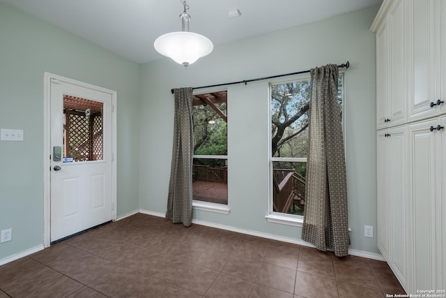 unfurnished dining area featuring tile patterned flooring and baseboards