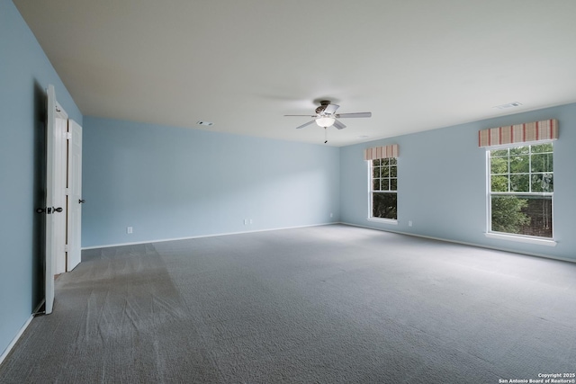 carpeted empty room with baseboards, visible vents, and ceiling fan