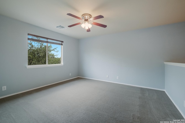 unfurnished room with dark colored carpet, visible vents, a ceiling fan, and baseboards