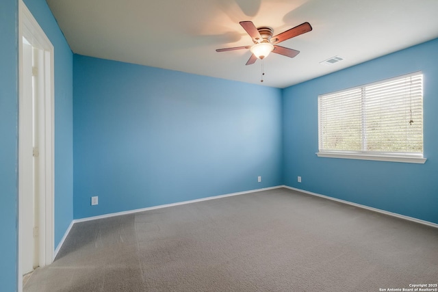 carpeted spare room with a ceiling fan, visible vents, and baseboards
