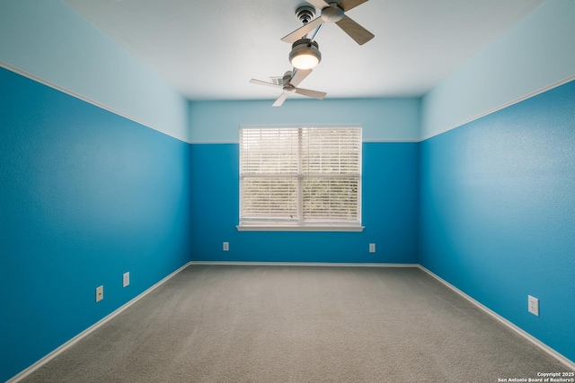 empty room featuring carpet, a ceiling fan, and baseboards