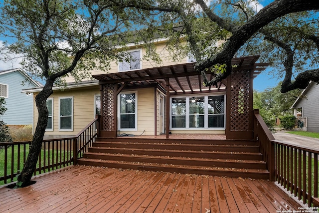 rear view of property featuring a pergola and a wooden deck