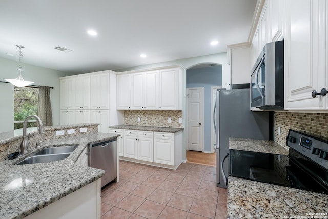 kitchen featuring light tile patterned floors, appliances with stainless steel finishes, backsplash, a sink, and visible vents
