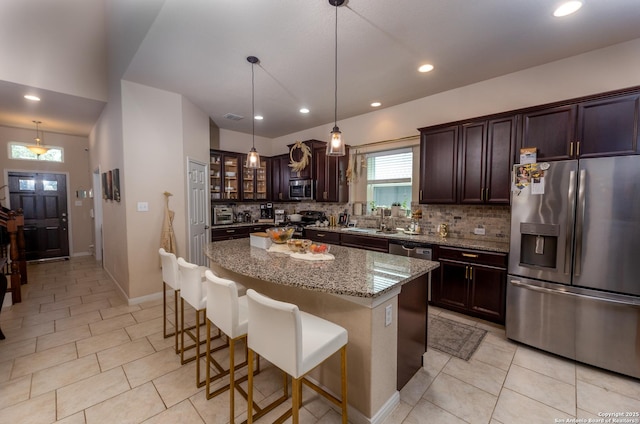 8701 Stackstone, Schertz, TX 78154 - kitchen featuring appliances with stainless steel finishes, decorative backsplash, a kitchen island, and dark brown cabinetry