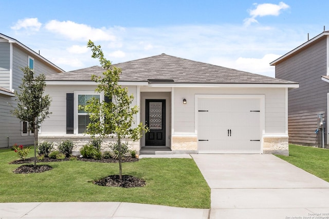 ranch-style home featuring roof with shingles, concrete driveway, a front yard, and an attached garage