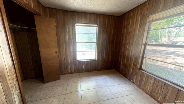 17 Fm 473, Comfort, TX 78013 - unfurnished bedroom with wood walls, a textured ceiling, and a closet