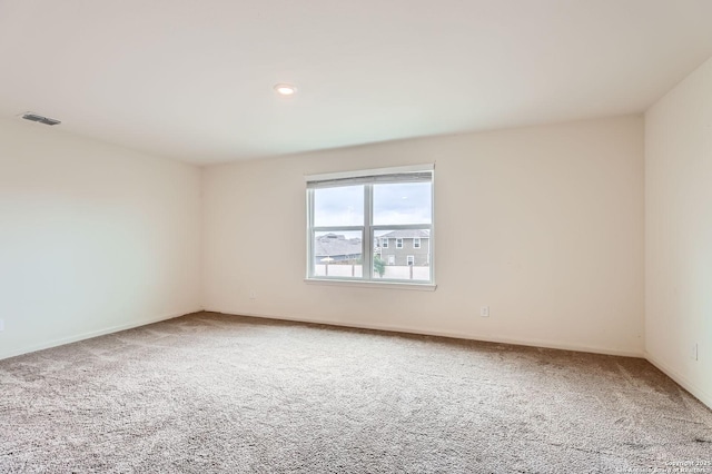 carpeted empty room featuring baseboards and visible vents