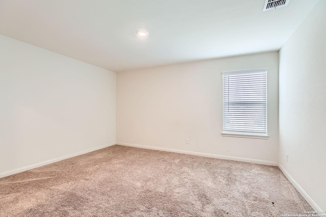 carpeted spare room featuring baseboards, visible vents, and recessed lighting
