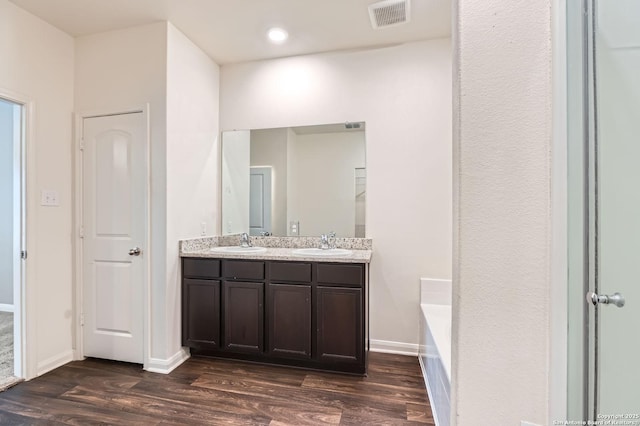 11846 Latour Vly, San Antonio, TX 78252 - bathroom featuring double vanity, wood finished floors, visible vents, and a sink