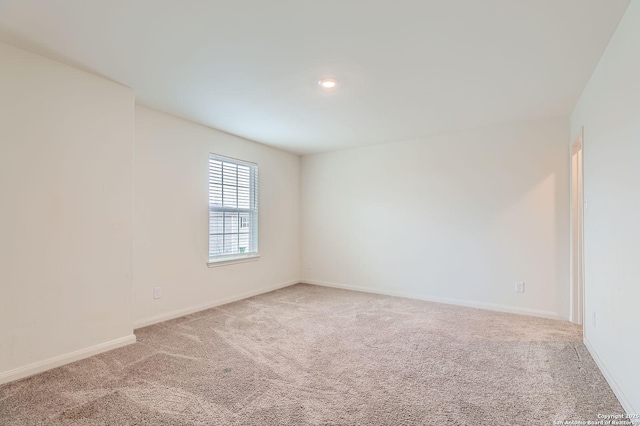 carpeted spare room with baseboards