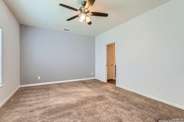 carpeted empty room with a ceiling fan, visible vents, and baseboards