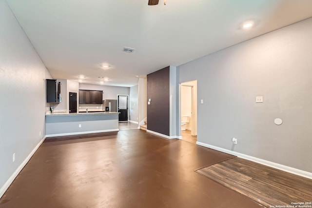 unfurnished living room with visible vents, concrete flooring, and baseboards