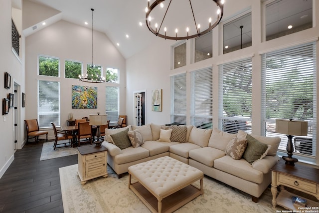living room featuring high vaulted ceiling, an inviting chandelier, dark wood-type flooring, and recessed lighting
