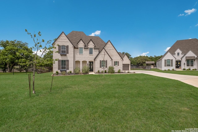 view of front of house featuring driveway, fence, and a front lawn