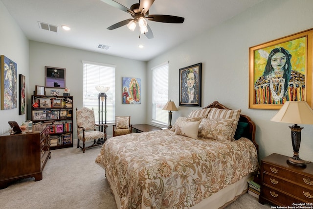 carpeted bedroom featuring a ceiling fan and visible vents