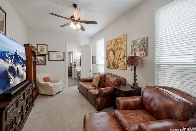 carpeted living room featuring a ceiling fan