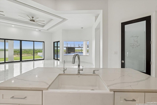 kitchen featuring plenty of natural light, a sink, light stone counters, and open floor plan