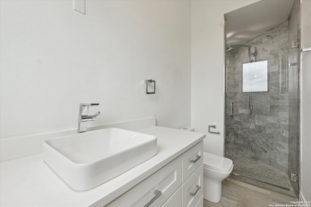 full bathroom featuring vanity, a shower stall, toilet, and wood finished floors