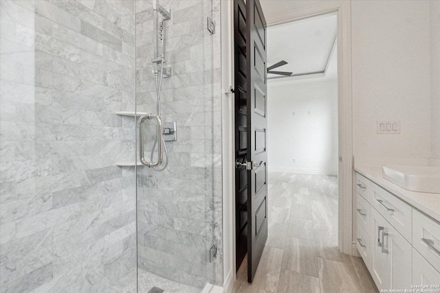 bathroom with vanity, baseboards, and a stall shower