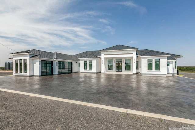 exterior space featuring central air condition unit, an attached garage, and driveway