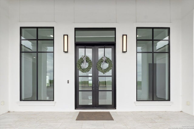 property entrance featuring french doors and stucco siding