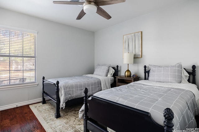 bedroom featuring a ceiling fan, multiple windows, wood finished floors, and baseboards