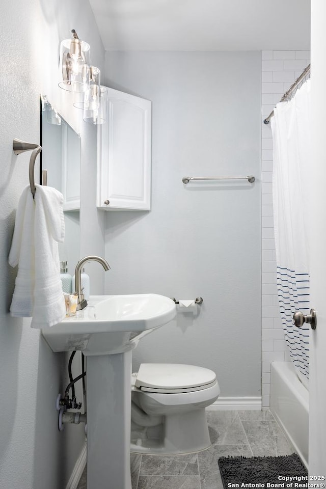 bathroom with baseboards, shower / bath combination with curtain, and toilet
