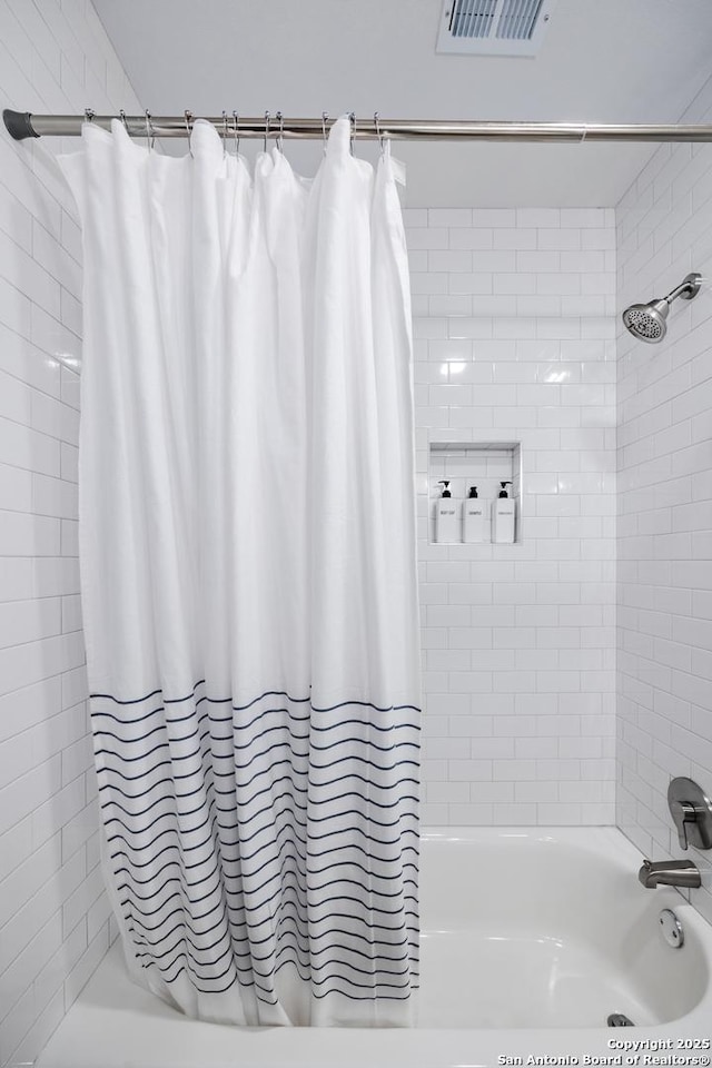 bathroom featuring shower / bath combo and visible vents
