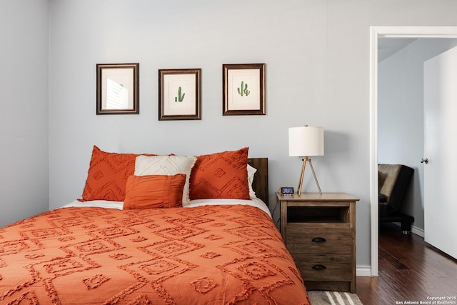 bedroom with dark wood-style floors and baseboards
