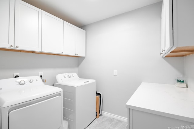 washroom with cabinet space, washing machine and clothes dryer, and baseboards