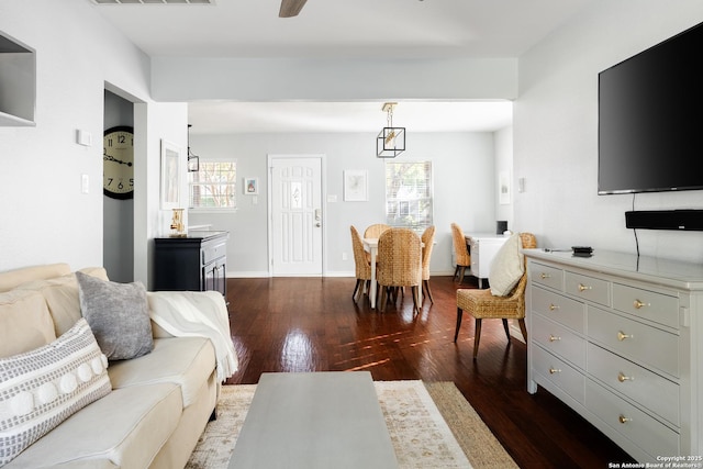living area featuring baseboards and dark wood finished floors