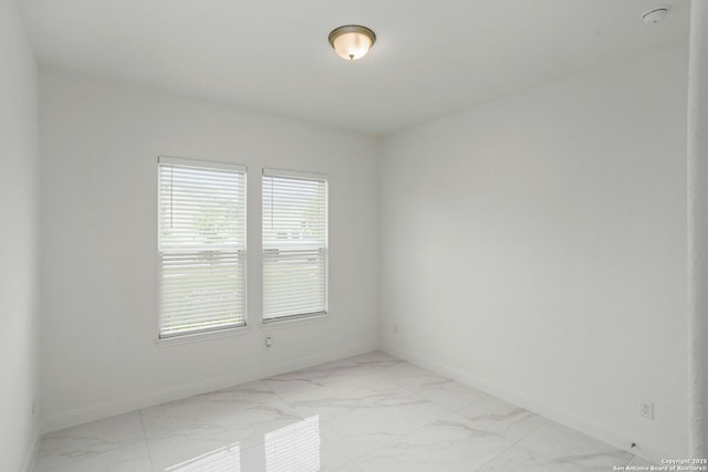 empty room with marble finish floor and baseboards