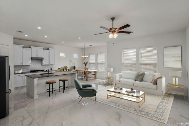 living room with visible vents, recessed lighting, a ceiling fan, and marble finish floor