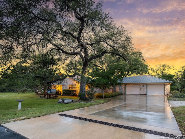 view of front facade with a standing seam roof, metal roof, a front lawn, and stone siding