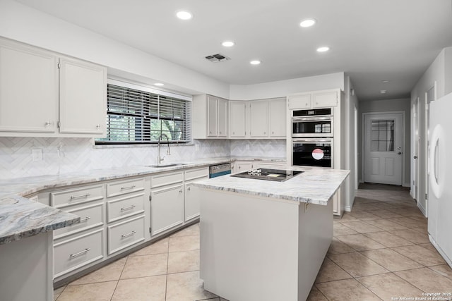kitchen featuring recessed lighting, freestanding refrigerator, a sink, visible vents, and dishwashing machine