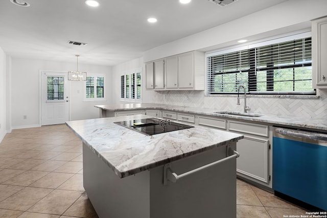 kitchen featuring tasteful backsplash, light tile patterned floors, a sink, a peninsula, and dishwashing machine