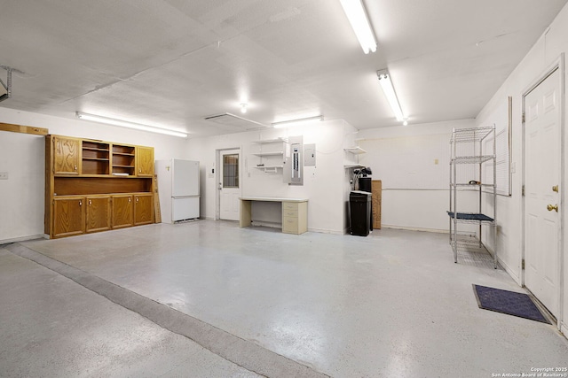 garage featuring electric panel and freestanding refrigerator