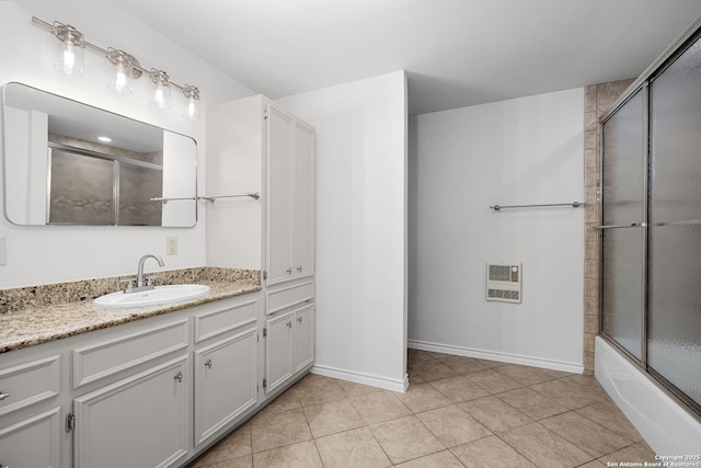 full bath with shower / bath combination with glass door, vanity, heating unit, tile patterned floors, and baseboards