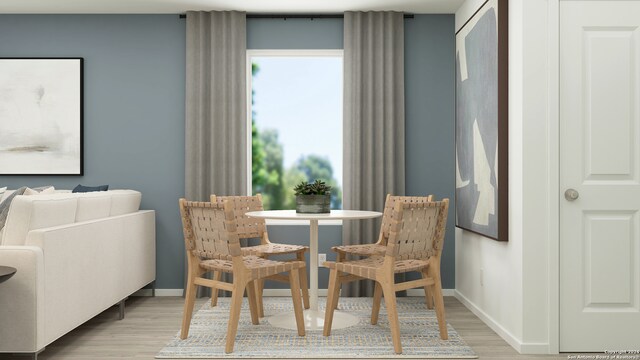 dining area featuring baseboards and light wood-type flooring