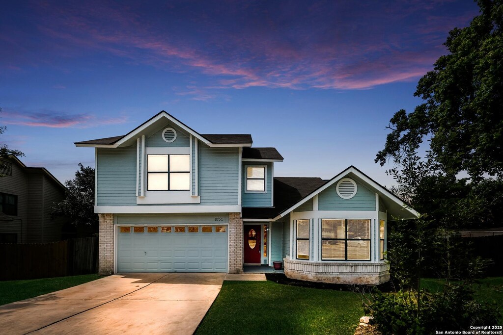 8752 Serene Rdg, San Antonio, TX 78239 - traditional-style home with brick siding, fence, a garage, driveway, and a lawn