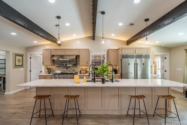 kitchen featuring light wood-type flooring, built in fridge, visible vents, backsplash, and baseboards