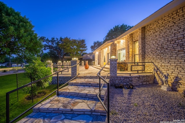 view of property exterior with fence and brick siding