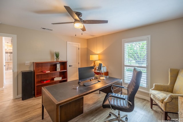 office space featuring visible vents, ceiling fan, baseboards, and light wood-type flooring