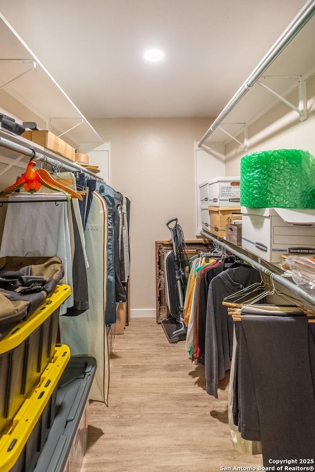 walk in closet with wood finished floors