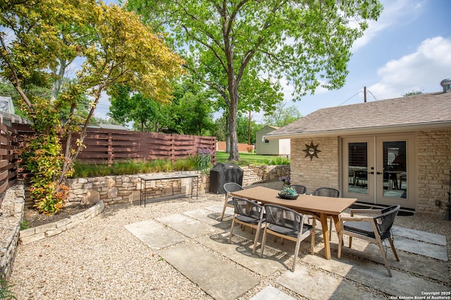view of patio / terrace with fence, outdoor dining space, french doors, and a grill
