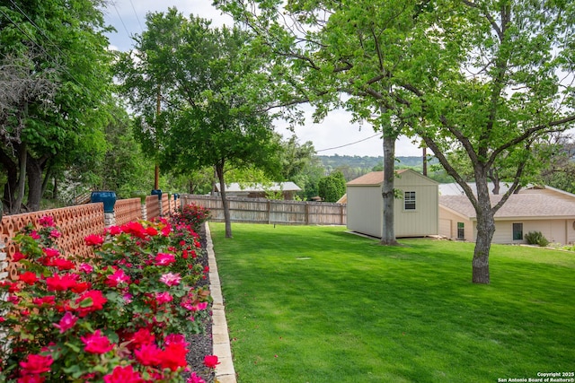 view of yard with an outbuilding, a storage shed, and fence