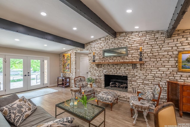 living room with recessed lighting, lofted ceiling with beams, light wood finished floors, a brick fireplace, and french doors