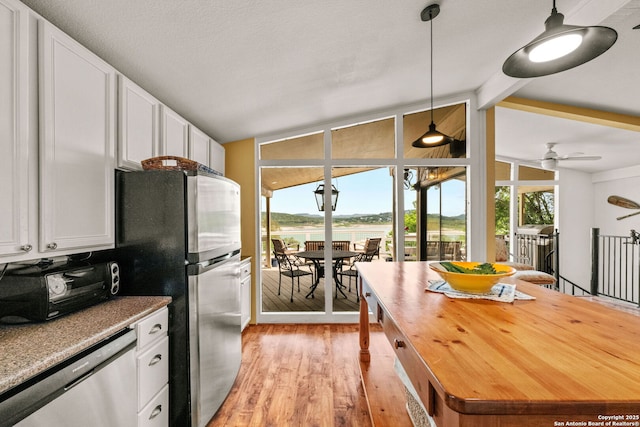 kitchen with light wood-type flooring, stainless steel appliances, plenty of natural light, and white cabinets